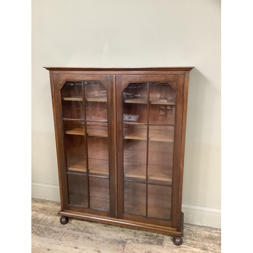 349 - A mahogany book case having two glazed tracery doors and on turned feet, 92cm wide x 27cm deep x 114... 