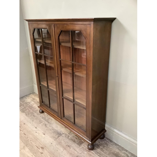 349 - A mahogany book case having two glazed tracery doors and on turned feet, 92cm wide x 27cm deep x 114... 