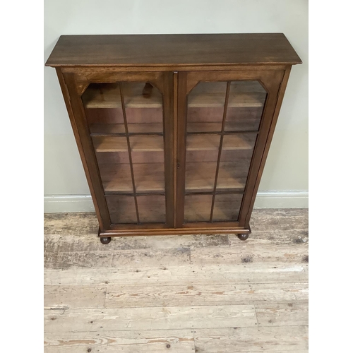 349 - A mahogany book case having two glazed tracery doors and on turned feet, 92cm wide x 27cm deep x 114... 