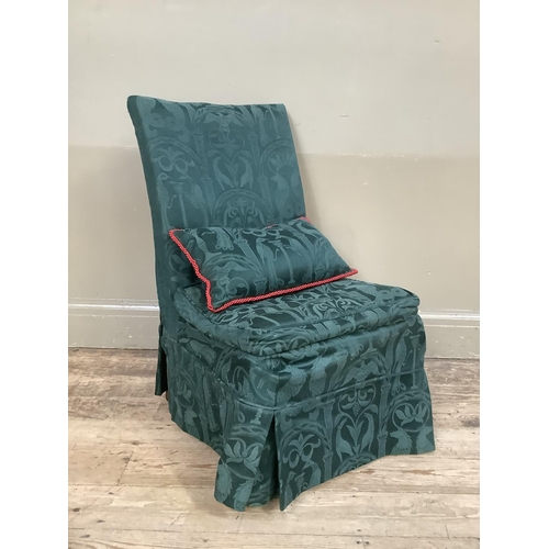 355 - A low set single chair with green upholstered fabric cover and pillow