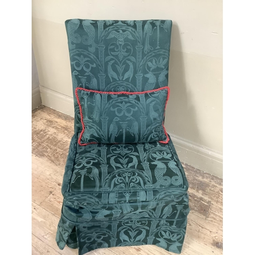 355 - A low set single chair with green upholstered fabric cover and pillow