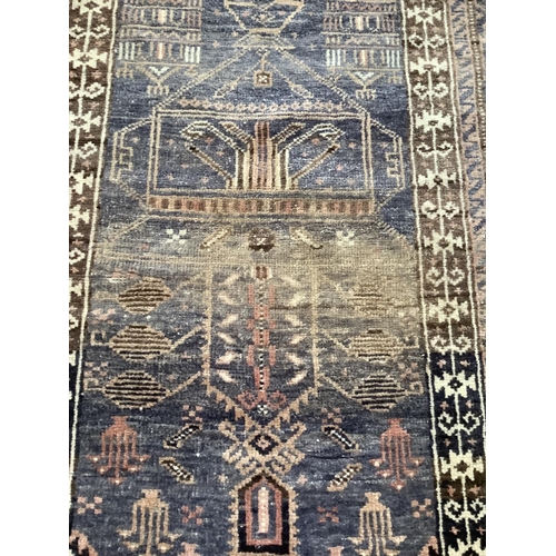 369 - A Middle Eastern rug, the blue field woven with a stylised vase of flowers within multiple borders, ... 