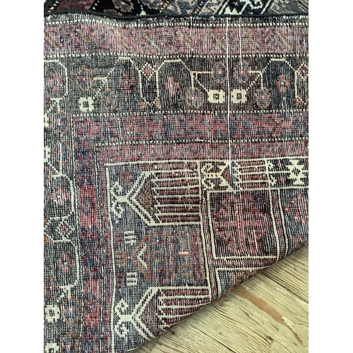 369 - A Middle Eastern rug, the blue field woven with a stylised vase of flowers within multiple borders, ... 