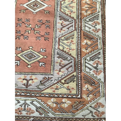 372 - A Middle Eastern rug having a coral field with stylised plant forms within two flory and counter flo... 