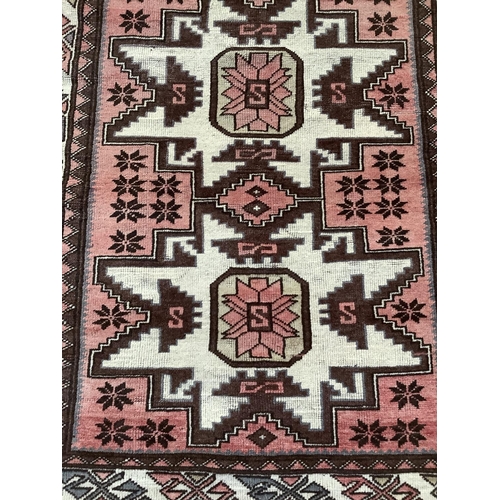 374 - A Turkish village rug having a central rose field with three conjoined star medallions within a main... 