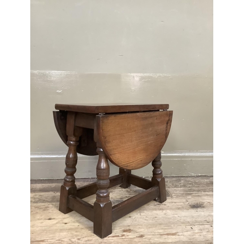 380 - An oak oval occasional drop leaf table on baluster turned and square framing