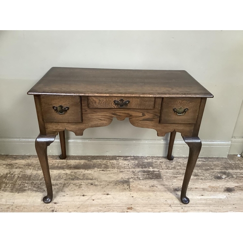 382 - A rectangular oak side table having three small drawers to the double ogee arched apron and on slend... 