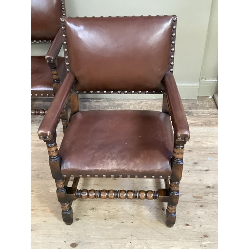 383 - A pair of oak open armchairs, brown hide upholstered with close nailing on turned and square framing