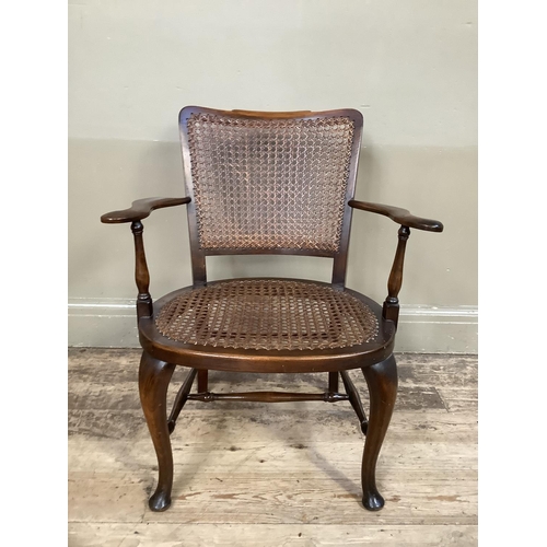 386 - A polished beech and bergere caned open armchair