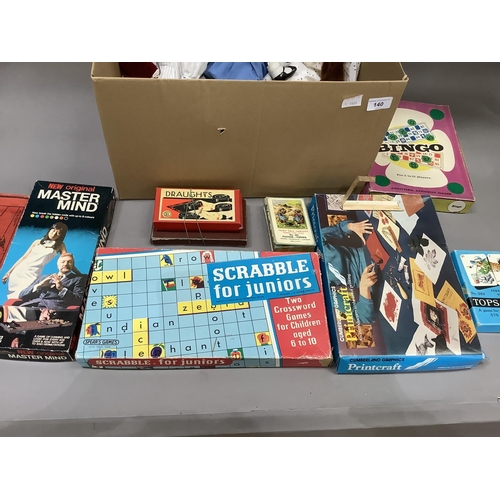 140 - A quantity of boxed games including Scrabble, Mastermind and others and three ceramic headed dolls (... 