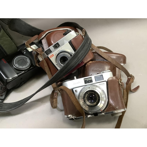 144 - A camera bag containing a Nikon TW Zoom 35-70 camera, a Kodak Retinette 1A, leather carrying case an... 