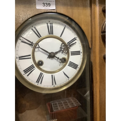 339 - A Victorian walnut wall clock having a white enamel two part dial with black Roman numerals, 8 day m... 