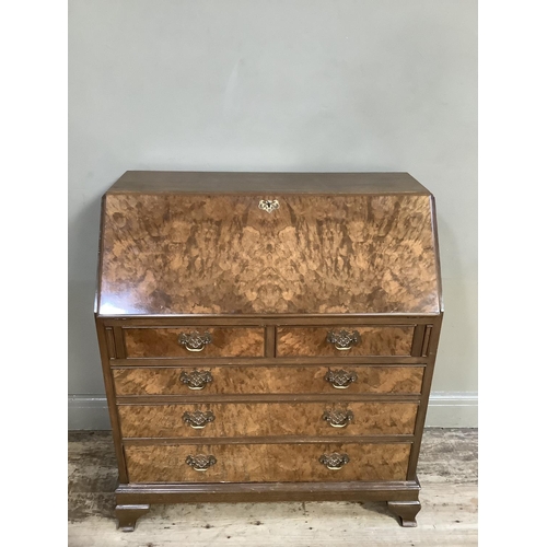 350 - A good reproduction figured walnut bureau having a fall front, the interior fitted above two short a... 