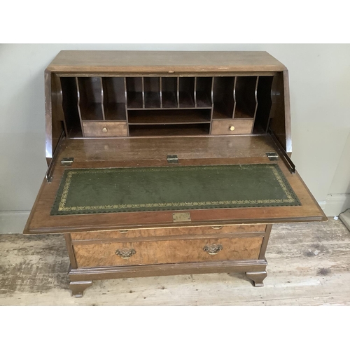 350 - A good reproduction figured walnut bureau having a fall front, the interior fitted above two short a... 