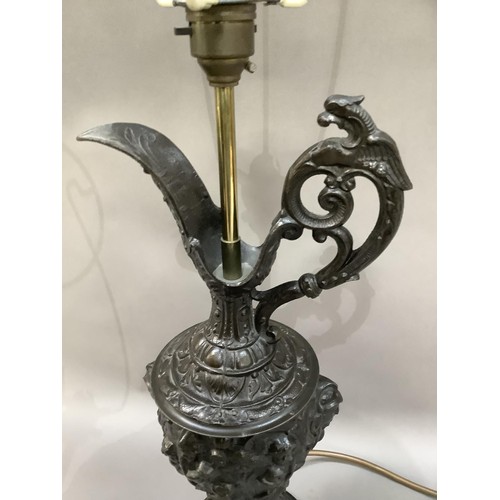 33 - A pair of spelter type ewers cast with cherubs and face masks as lamps, with shades