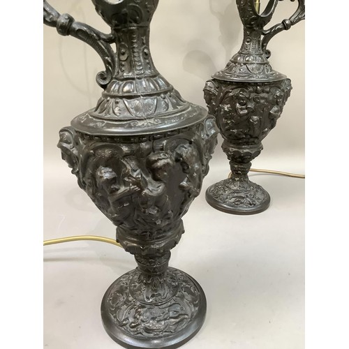 33 - A pair of spelter type ewers cast with cherubs and face masks as lamps, with shades