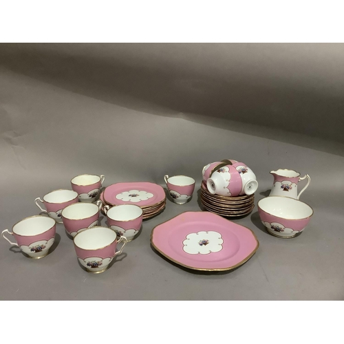 105 - A Court china tea service of rose pink ground centred with a basket of flowers, a gilt rim line comp... 