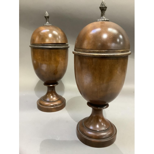 192 - A pair of treen lidded urns, the domed covers with bud finials, knopped pedestal and circular steppe... 