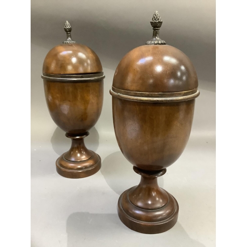 192 - A pair of treen lidded urns, the domed covers with bud finials, knopped pedestal and circular steppe... 