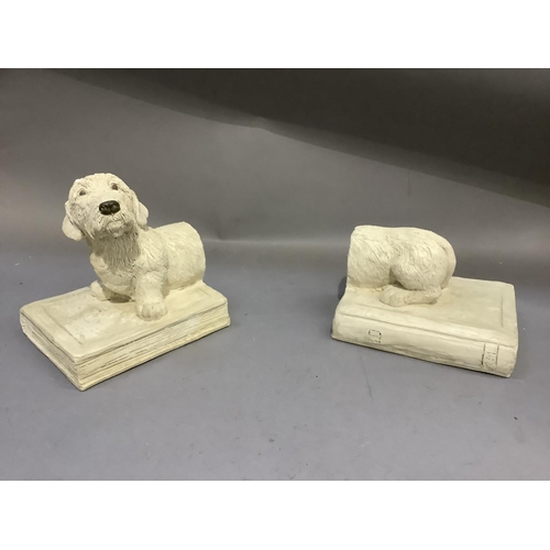 196 - A pair of ceramic bookends modelled as a sausage dog sitting upon a book, incised signature, illegib... 