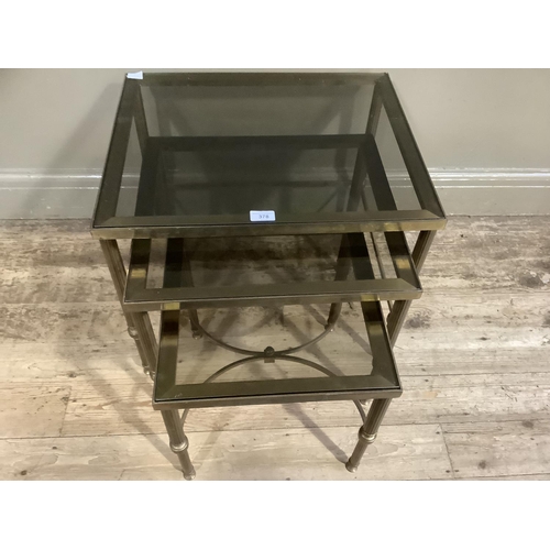 378 - A nest of three smoked glass and gilt metal coffee tables