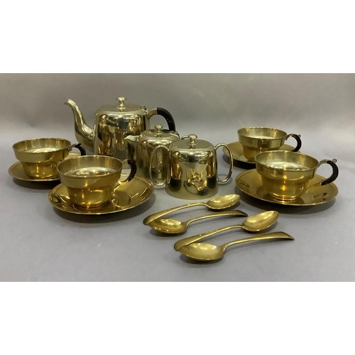 112 - A brass tea service comprising teapot, sugar ,and cream, four cups, saucers and teaspoons