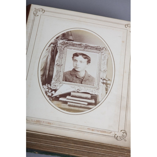 29 - A Victorian green leather bound photograph album containing solo and group portraits