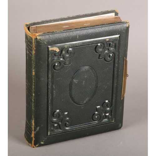 29 - A Victorian green leather bound photograph album containing solo and group portraits