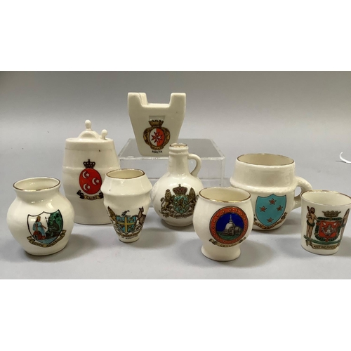 329 - A group of W. H. Goss porcelain overseas souvenirs including Maltese Fire Grate with matching crest,... 