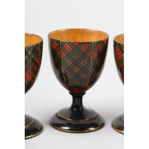 61 - A SET OF FOUR VICTORIAN TARTAN WARE EGG CUPS in McFarlane, McBeth, Stuart and McLean, 7cm high