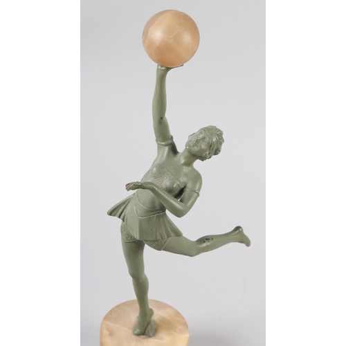 110 - AN ART DECO VERDIGRIS - FINISHED METAL FIGURE OF A DANCER, her arm raised and holding an alabaster b... 