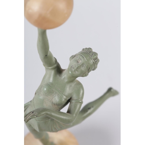 110 - AN ART DECO VERDIGRIS - FINISHED METAL FIGURE OF A DANCER, her arm raised and holding an alabaster b... 