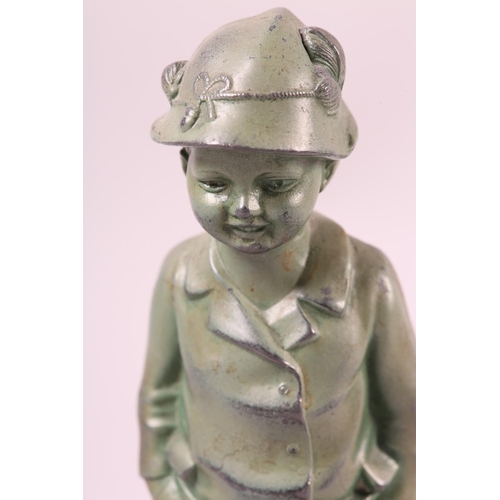 111 - AN ART DECO VERDIGRIS FINISHED METAL FIGURE OF A YOUNG BOY, wearing a feather trimmed hat, jacket an... 