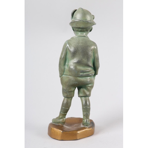 111 - AN ART DECO VERDIGRIS FINISHED METAL FIGURE OF A YOUNG BOY, wearing a feather trimmed hat, jacket an... 