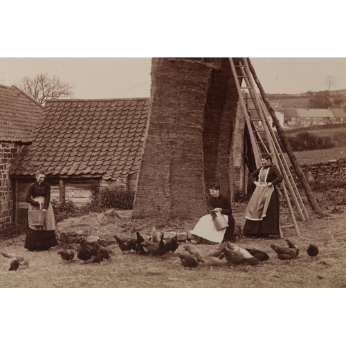 21 - FRANK MEADOW SUTCLIFFE (1853-1941), Farm girls feeding the chickens beside a tall haystack, c.1880, ... 