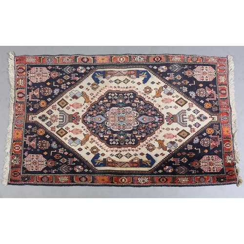 A MIDDLE EASTERN RUG, the ivory ground with indigo medallion filled