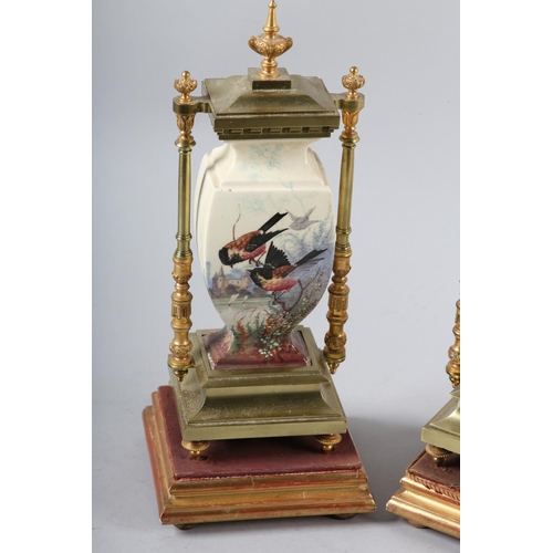 95 - A PAIR OF 19TH CENTURY GILDED BRASS AND CERAMIC CLOCK garnitures of urn shape printed and enamelled ... 