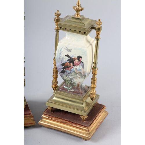 95 - A PAIR OF 19TH CENTURY GILDED BRASS AND CERAMIC CLOCK garnitures of urn shape printed and enamelled ... 