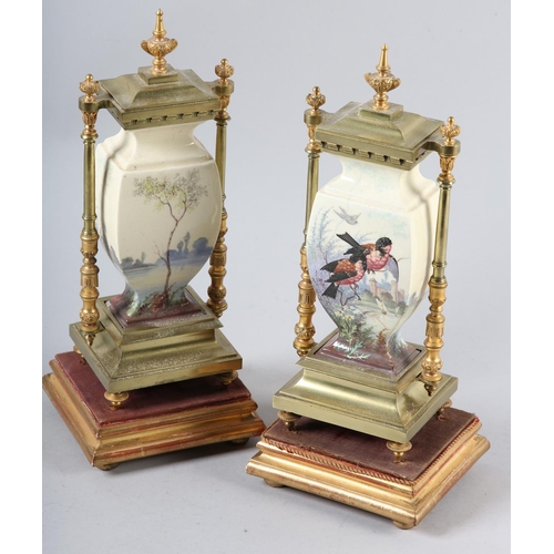 95 - A PAIR OF 19TH CENTURY GILDED BRASS AND CERAMIC CLOCK garnitures of urn shape printed and enamelled ... 