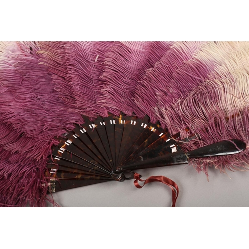 102 - An ostrich feather fan, shaded from purple to lilac and ending in cream, the monture of tortoiseshel... 