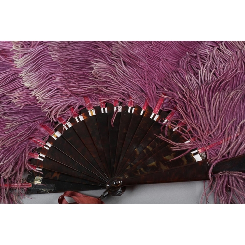 102 - An ostrich feather fan, shaded from purple to lilac and ending in cream, the monture of tortoiseshel... 