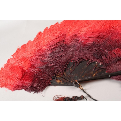 105B - c.1900, an ostrich feather fan, the plumes deep plum shaded to red, with tortoiseshell monture, the ... 