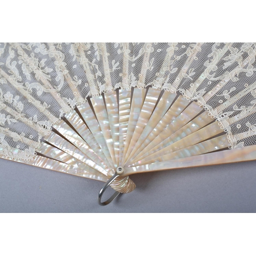 149 - A folding fan c 1900 with pink mother of pearl monture, continuing onto the ribs, the lace leaf of a... 