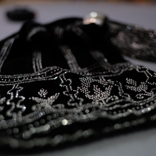 321 - An unusually large miser’s purse in black velvet, lavishly embroidered in cut steel beads, one large... 