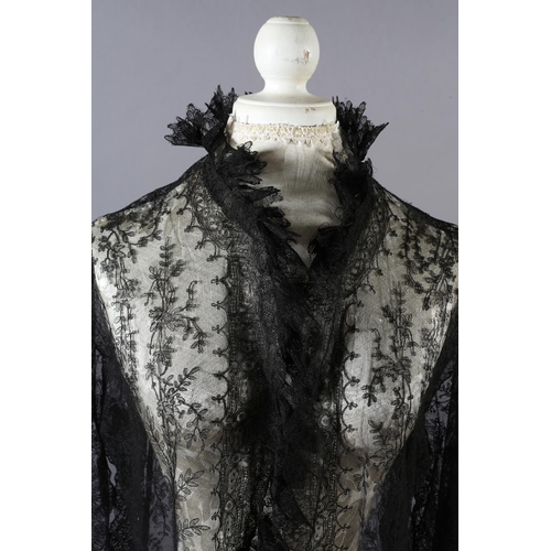 356 - A black machine lace long sleeved coat, 19th century, most likely formed from a large shawl, the cuf... 