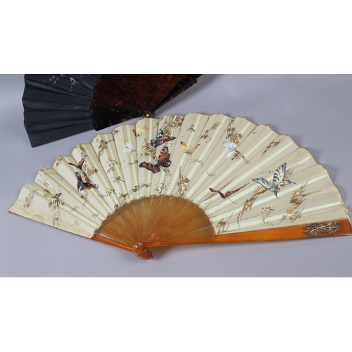 54 - A c.1890’s gauze fan painted with butterflies, signed “Antoinette”, the leaf mounted on blonde torto... 