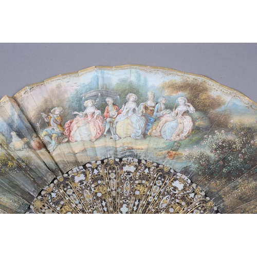 56B - An ornate mid-19th century mother of pearl fan, the guards entirely of carved and pierced gilt metal... 