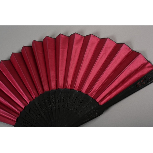 62 - Three late 19th century fans, all with wood montures, with decorative gilding, the cerise silk leaf,... 