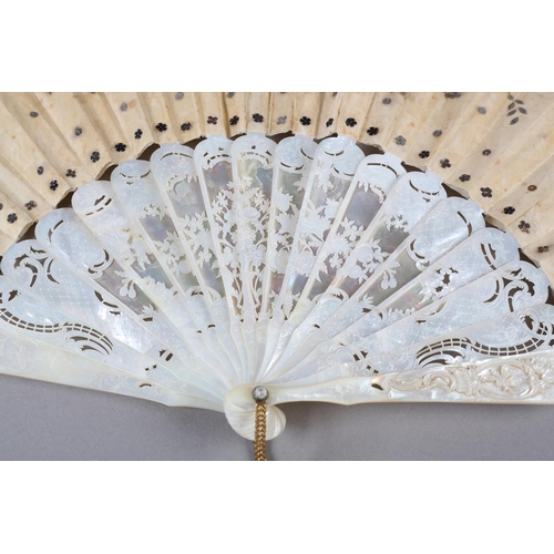 84 - A c.1880’s mother of pearl fan with very elaborate carving, the guards pierced then applied with por... 