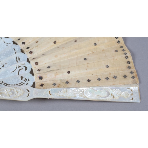 84 - A c.1880’s mother of pearl fan with very elaborate carving, the guards pierced then applied with por... 